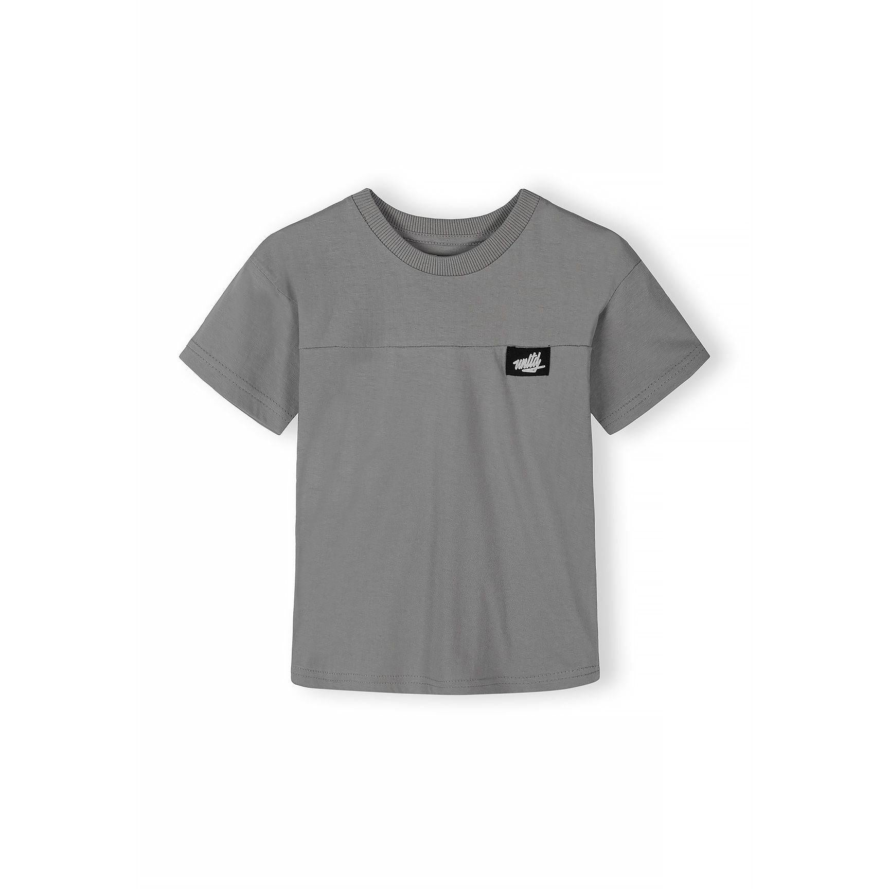 Close-up detail of black fabric label with white Minoti logo on grey t-shirt chest area