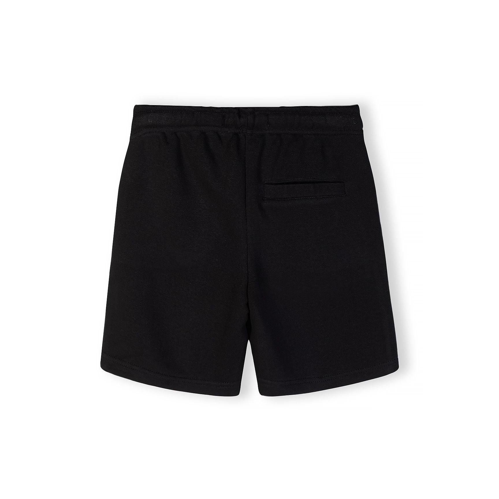 Close-up front view of black t-shirt showing detailed The Future is Now circular white text print with Japanese characters below