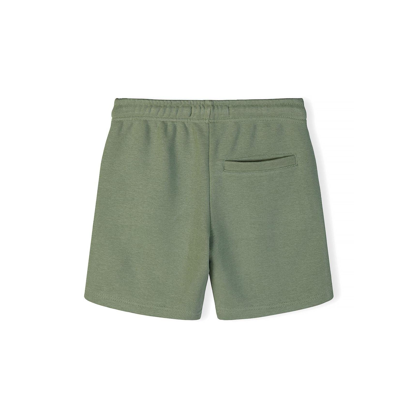 Close-up detail of olive green t-shirt fabric showing 'The Future Is Just Starting' print with Korean text underneath and Minoti label at neckline