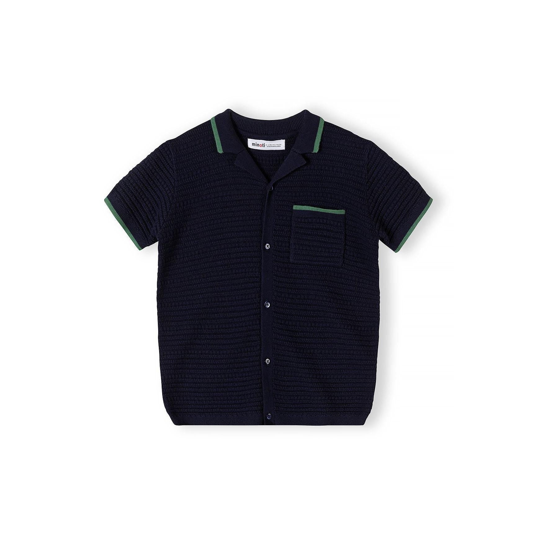 Close-up detail of navy blue knitted polo shirt showing Minoti label, button placket, chest pocket with green piping trim