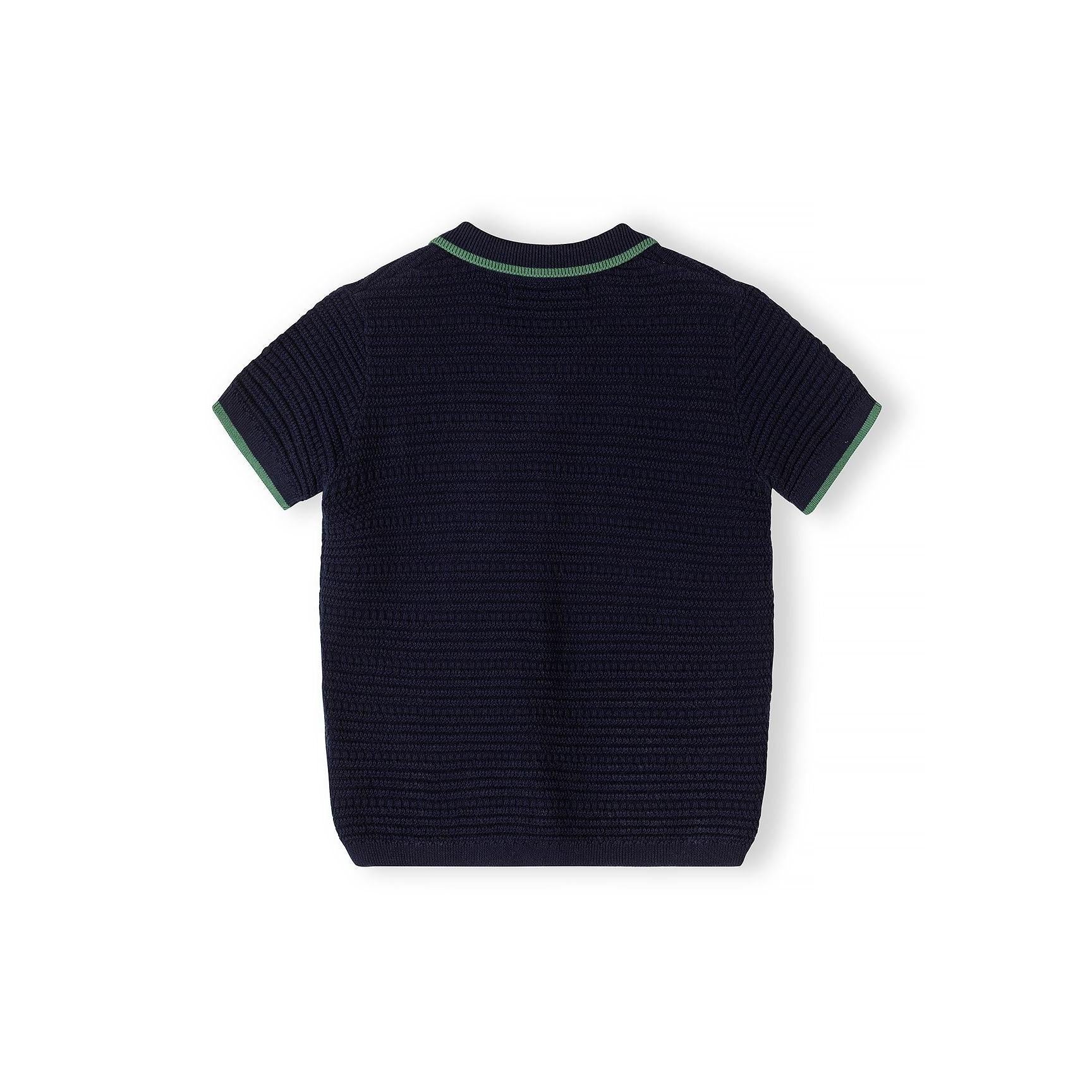 Back view of navy blue knitted polo shirt showing textured waffle-knit fabric and green contrast trim at neckline and sleeves