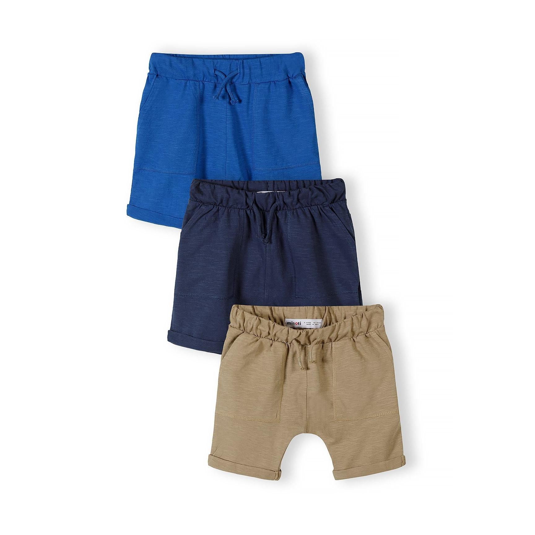Three cotton slub jersey shorts in camel, navy and blue laid flat in staggered arrangement on white background