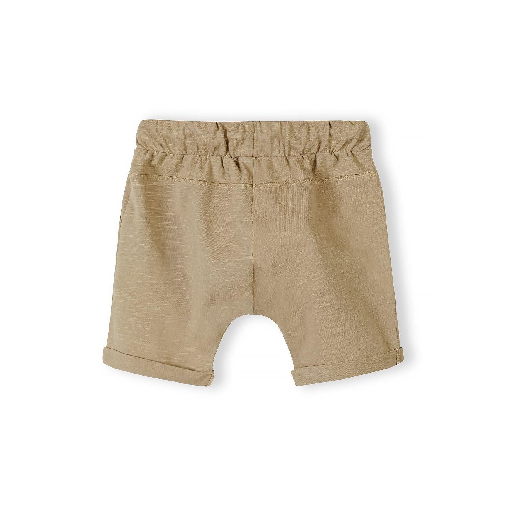 Close-up detail of camel shorts showing elasticated waistband with toggle drawstring closure and fabric texture