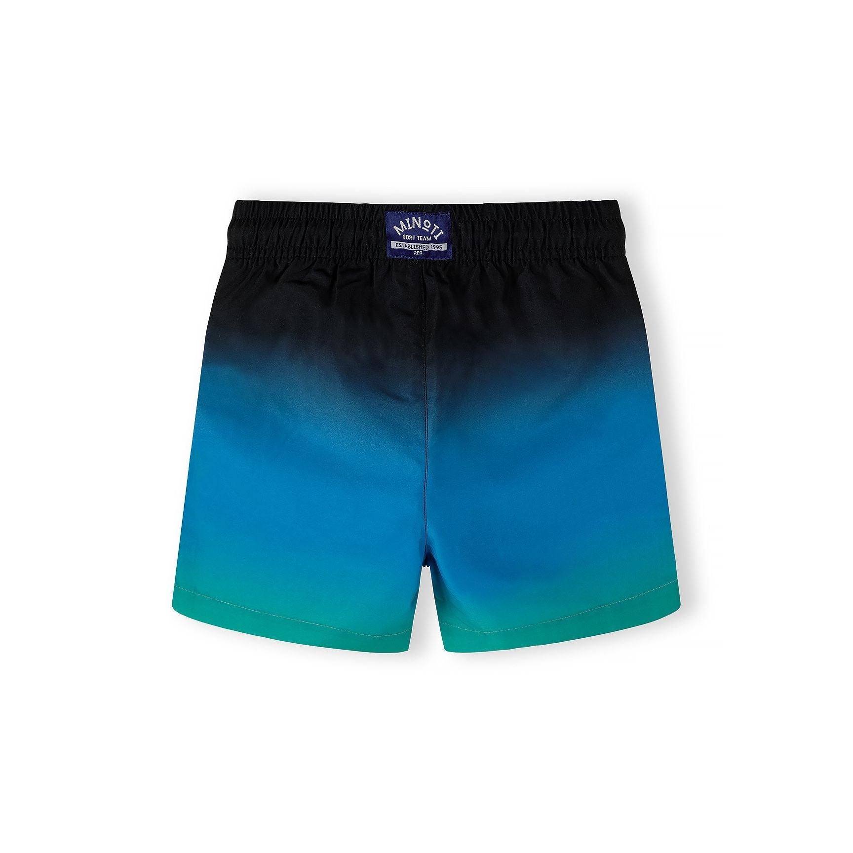 Close-up detail of black fabric with colorful palm tree print showing teal, blue and yellow tropical design elements