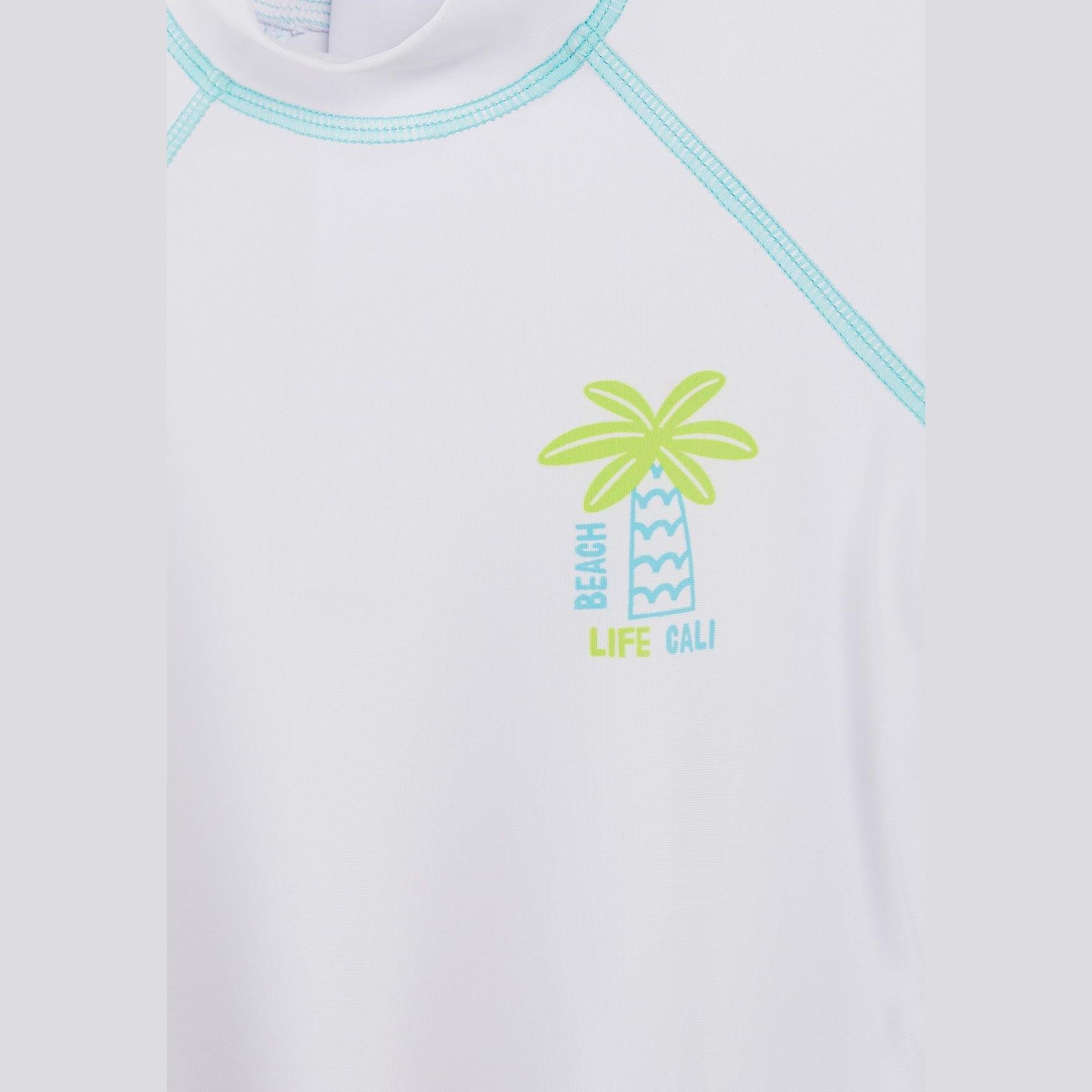 Detail view of white rash vest showing aqua contrast stitching around neckline and sleeves, with tropical palm tree graphic and 'Beach Life Cali' text