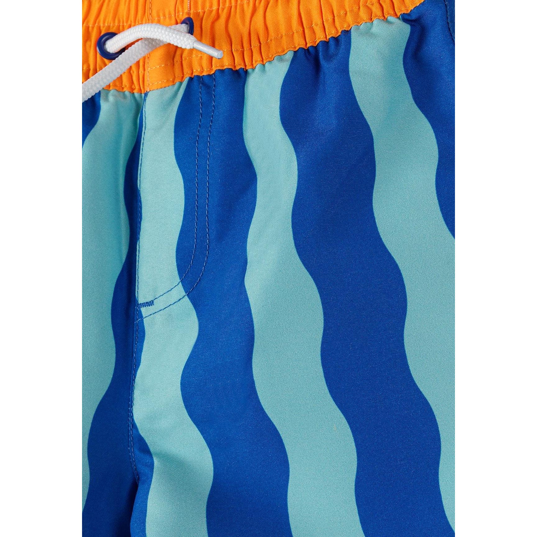 Close-up detail of swimming shorts waistband showing orange elasticated fabric with white drawstring and blue wavy stripe pattern below