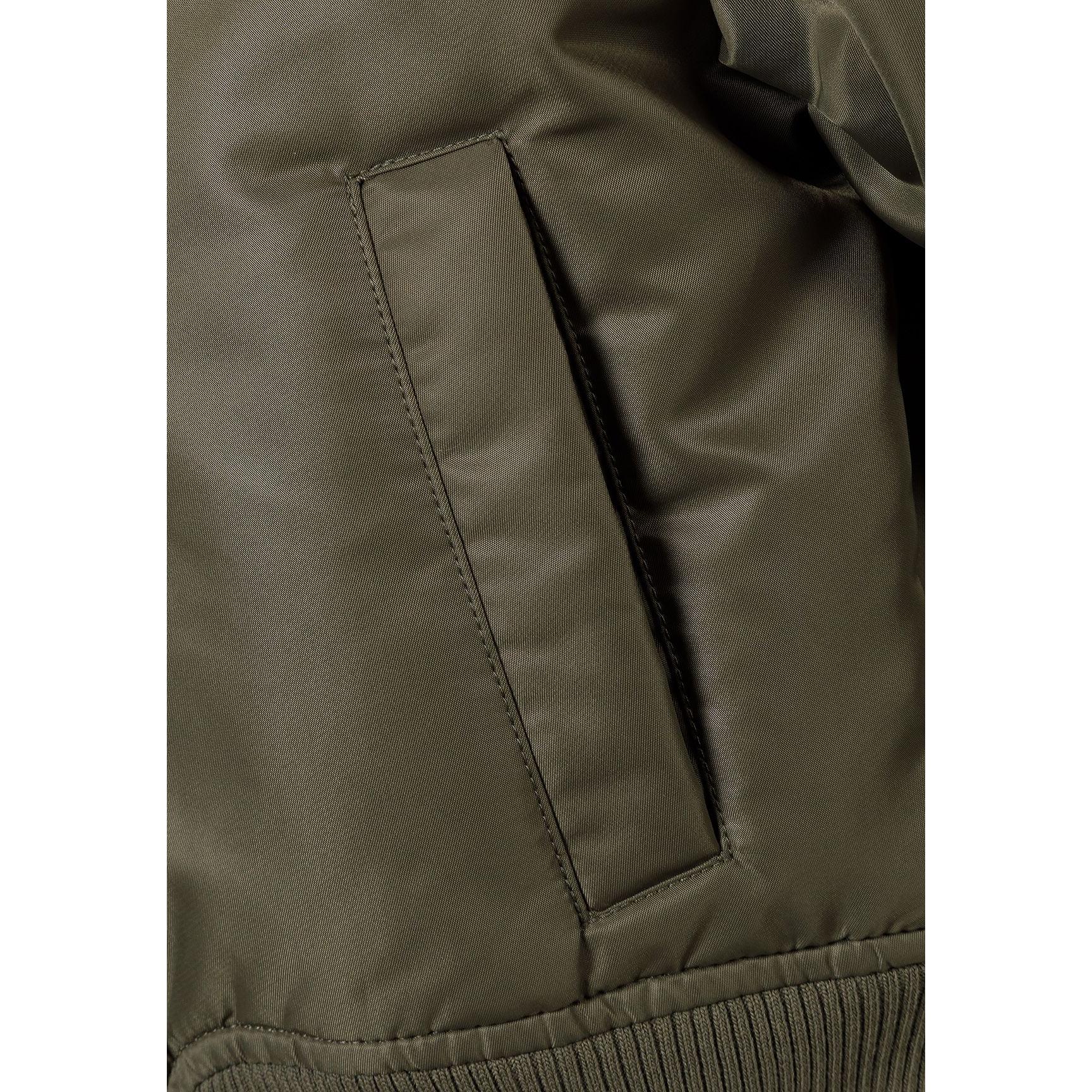 Close-up detail of khaki bomber jacket showing quilted padding texture and stitching construction