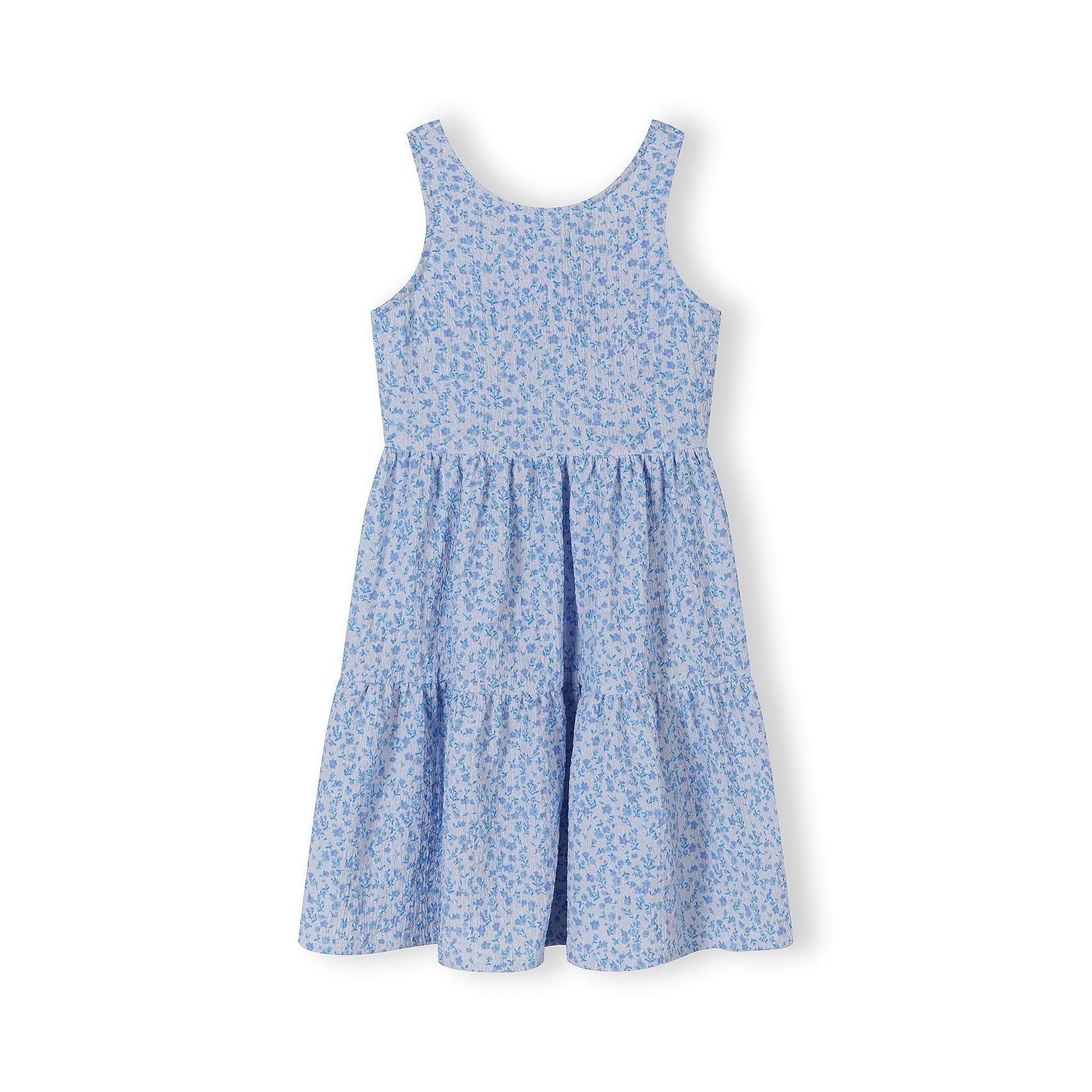 Front view flat lay of blue floral sleeveless tiered dress with round neckline on white background