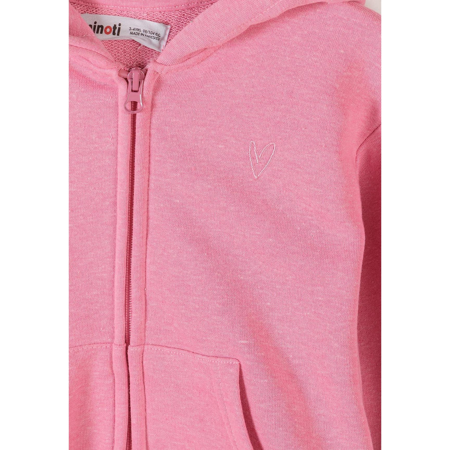 Close-up detail of pink hoodie showing Minoti label, zip closure and embroidered heart logo on chest area