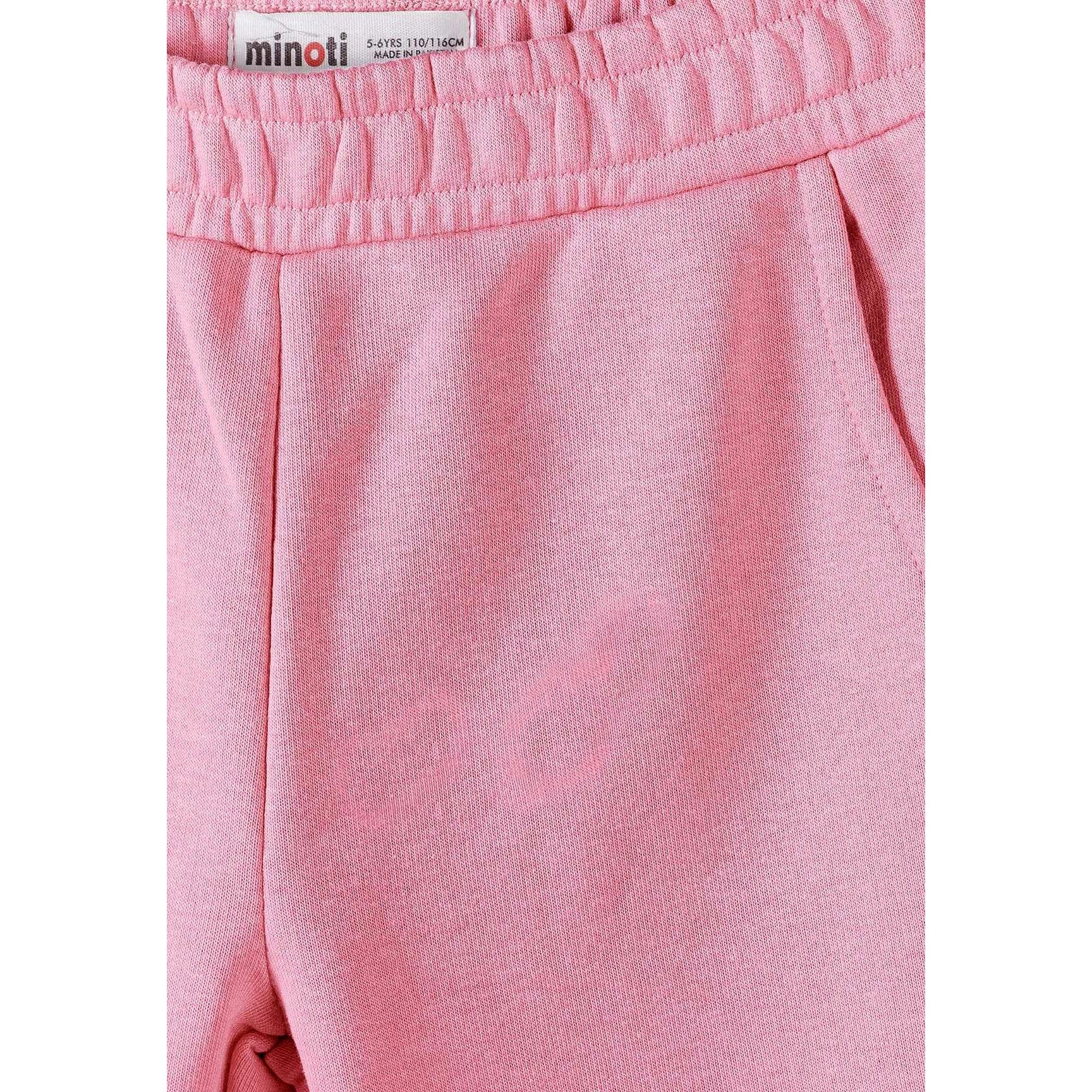 Close-up detail of coral pink jogger showing Minoti label on elasticated waistband and soft knit fabric texture