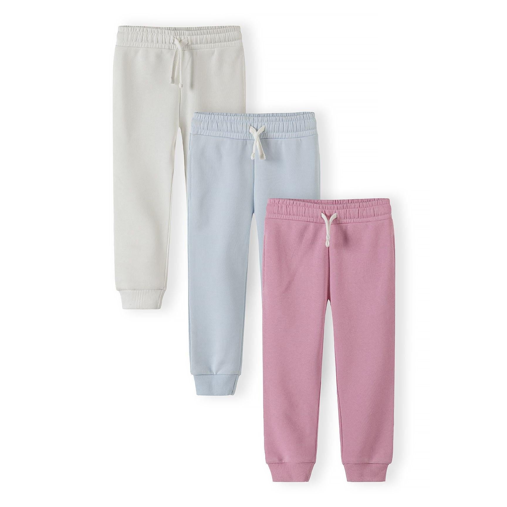 Three joggers laid flat showing light blue, white and pink colours with drawstring waistbands and ribbed cuffs