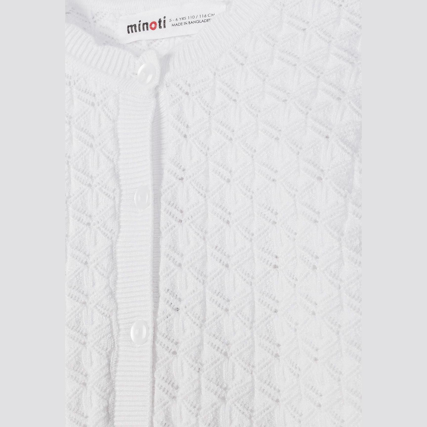 Close-up detail of white cardigan showing Minoti label and intricate wavy knit pattern texture