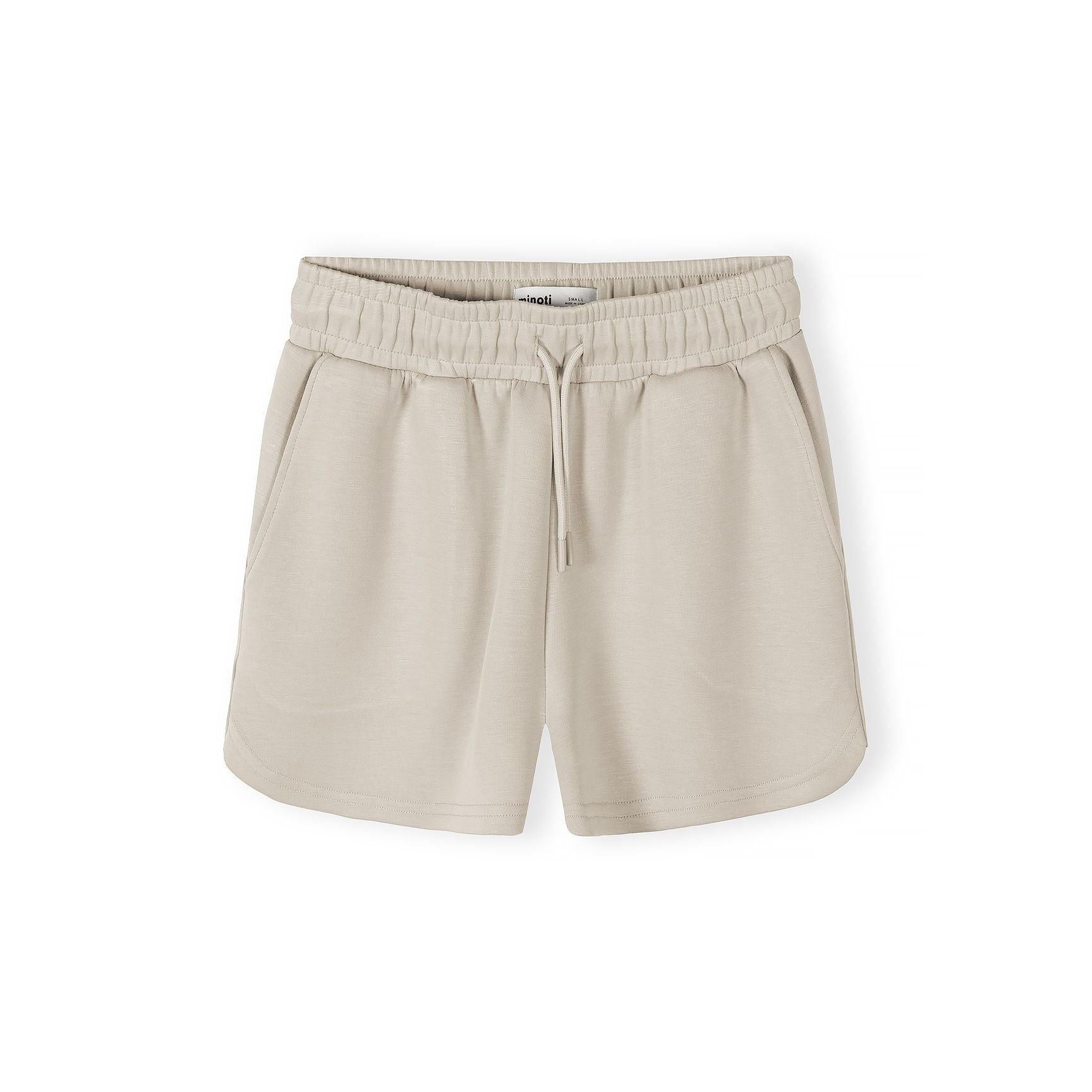 Close-up of beige shorts showing elasticated waistband with drawstring and side pockets
