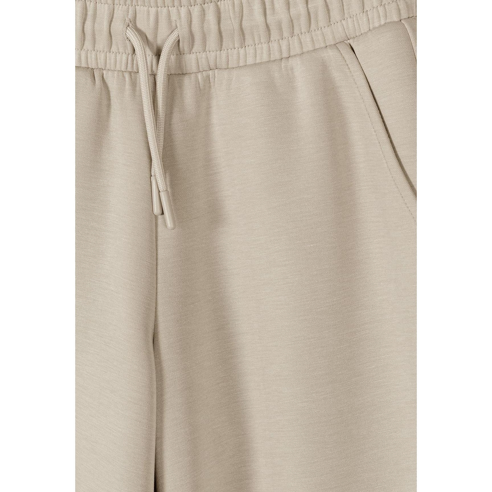 Close up detail of beige joggers waistband with elasticated band and drawstring