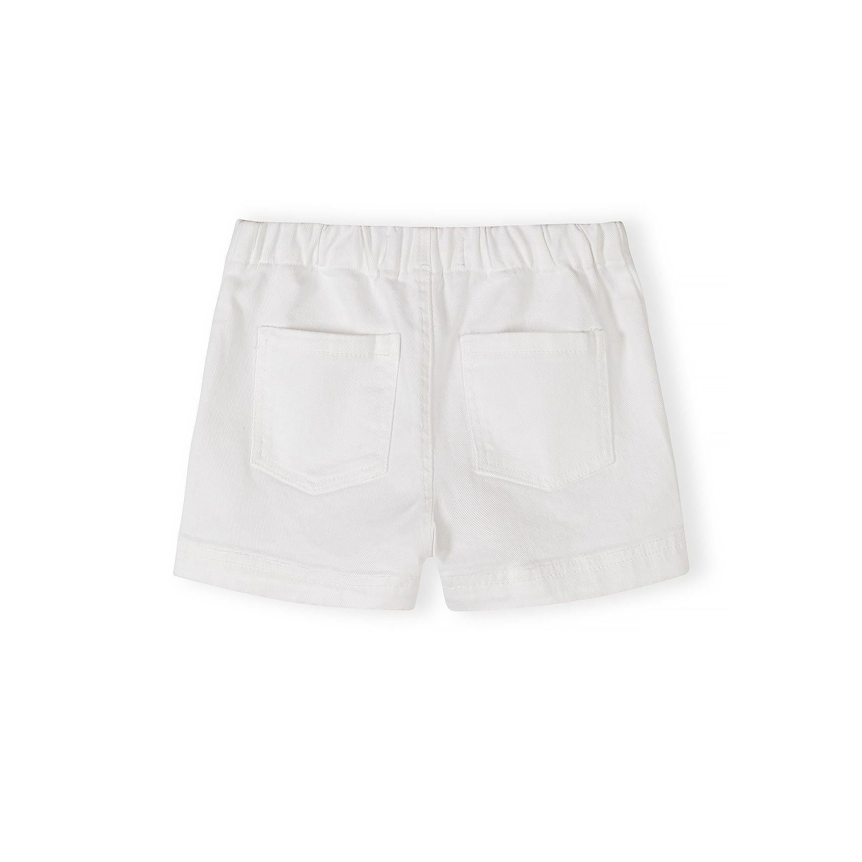 Close-up detail of white twill shorts showing button fastening, drawstring ties and fabric texture against neutral background