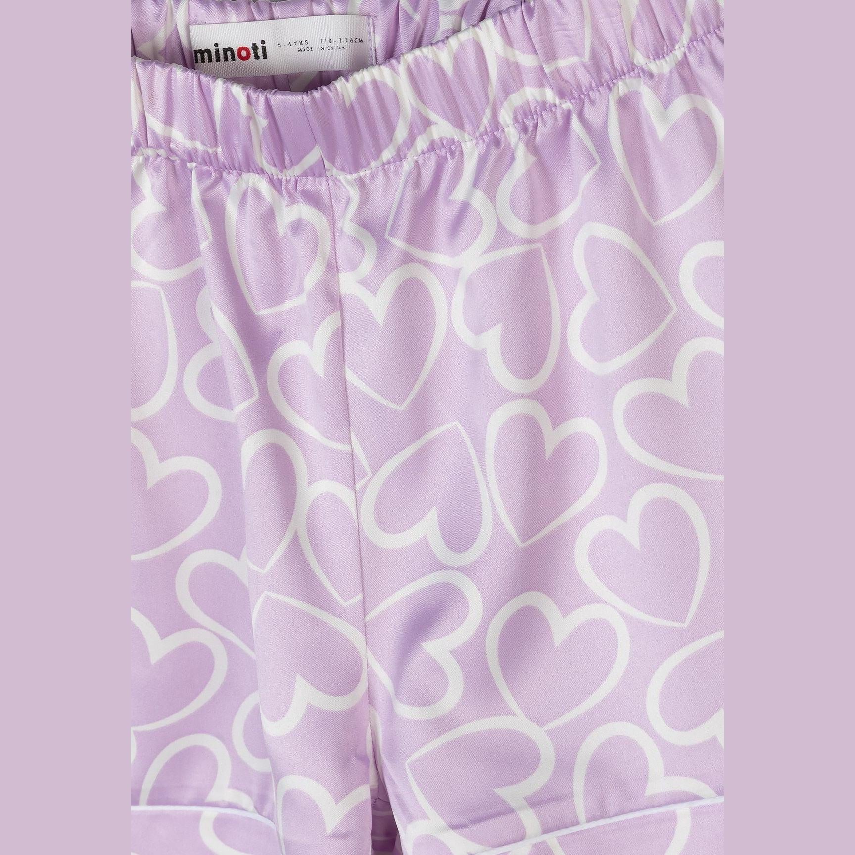 Detail shot of pyjama shorts waistband showing elastic construction and Minoti brand label on lilac background