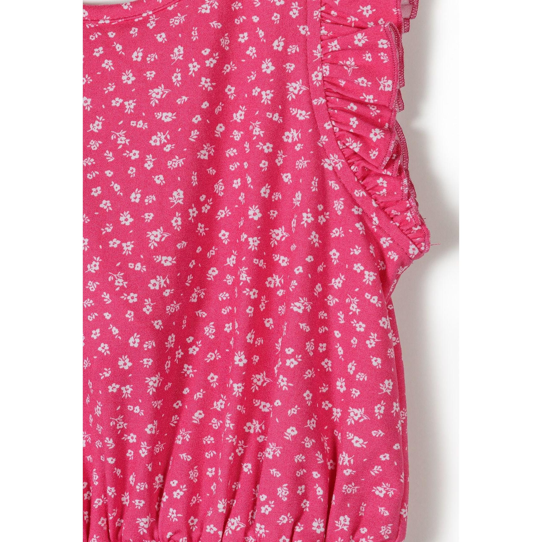 Close-up detail of pink fabric showing white floral pattern and ruffled sleeve construction