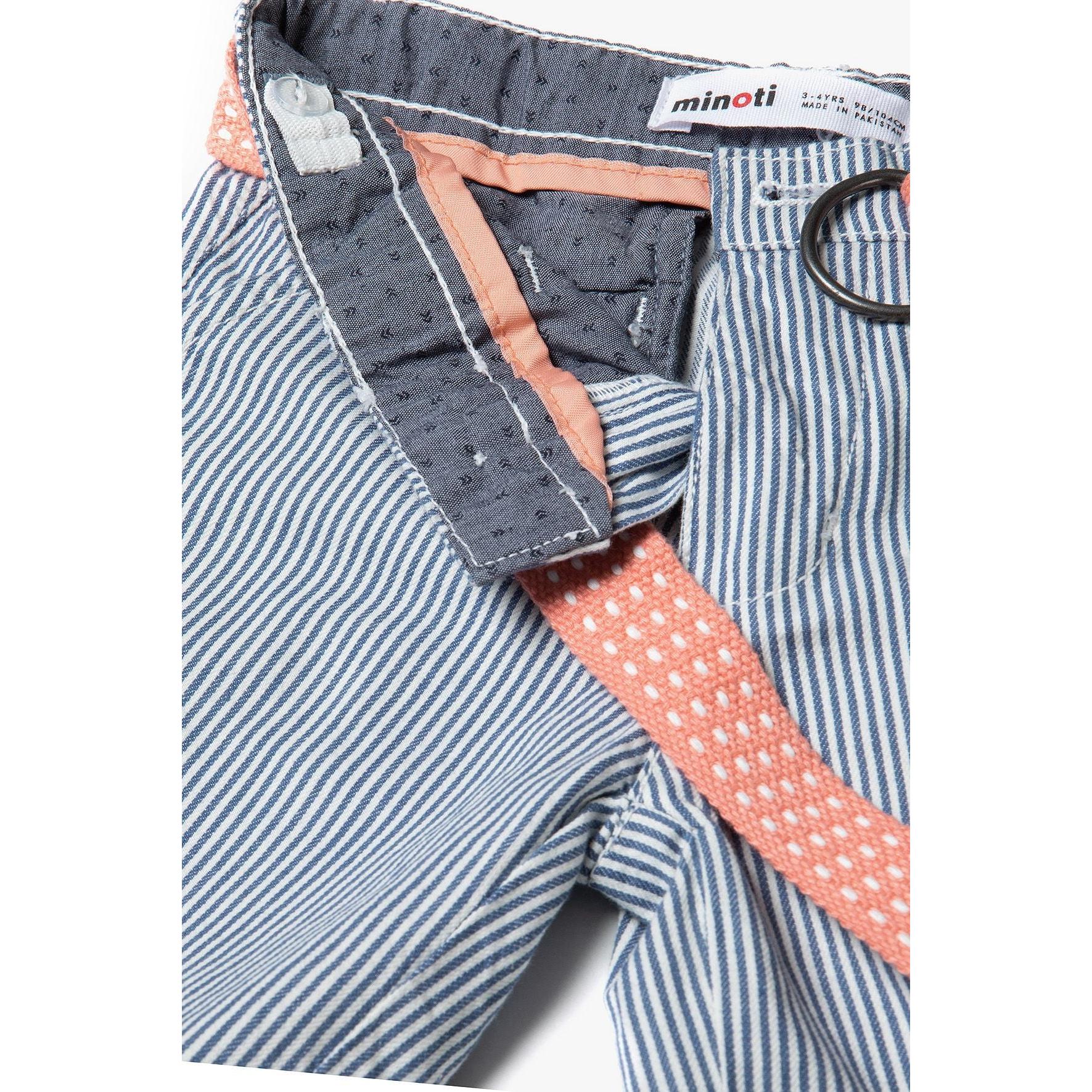 Close-up detail of Minoti label inside waistband and coral canvas belt against blue striped cotton fabric