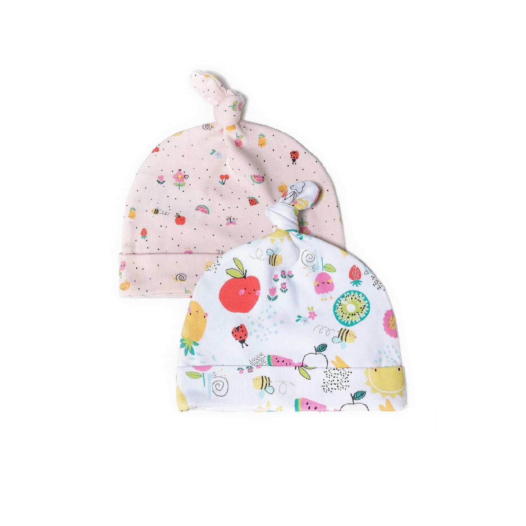 Two baby hats displayed against white background, one pink with small fruit prints and one white with colorful fruit and animal motifs including apples, bees and flowers