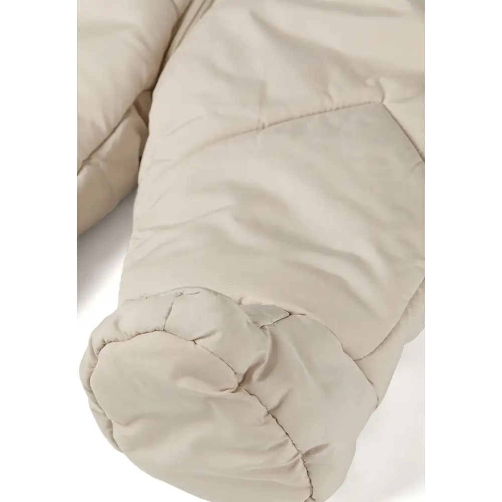 Close-up detail of attached quilted mittens showing cream padding and stitching construction on cream snowsuit