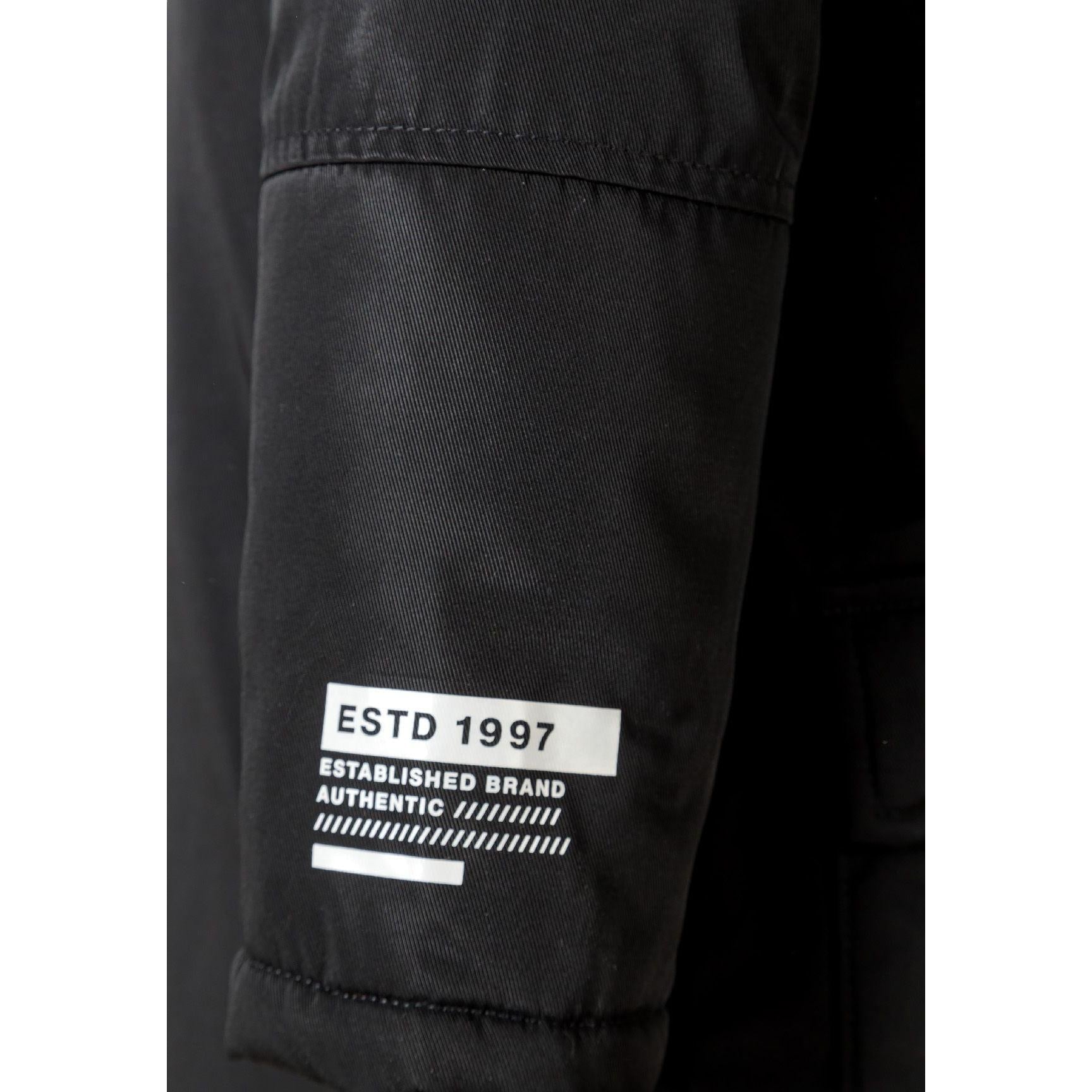 Close-up detail of black parka hood with grey faux fur trim showing attachment buttons and fabric texture