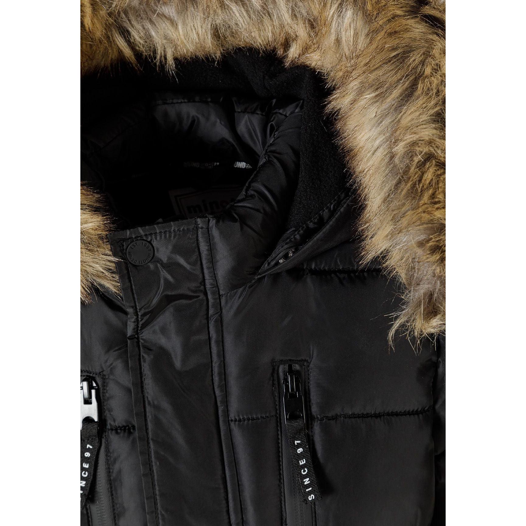 Close-up detail of faux fur hood trim and black fabric showing quilted pattern and zipper details