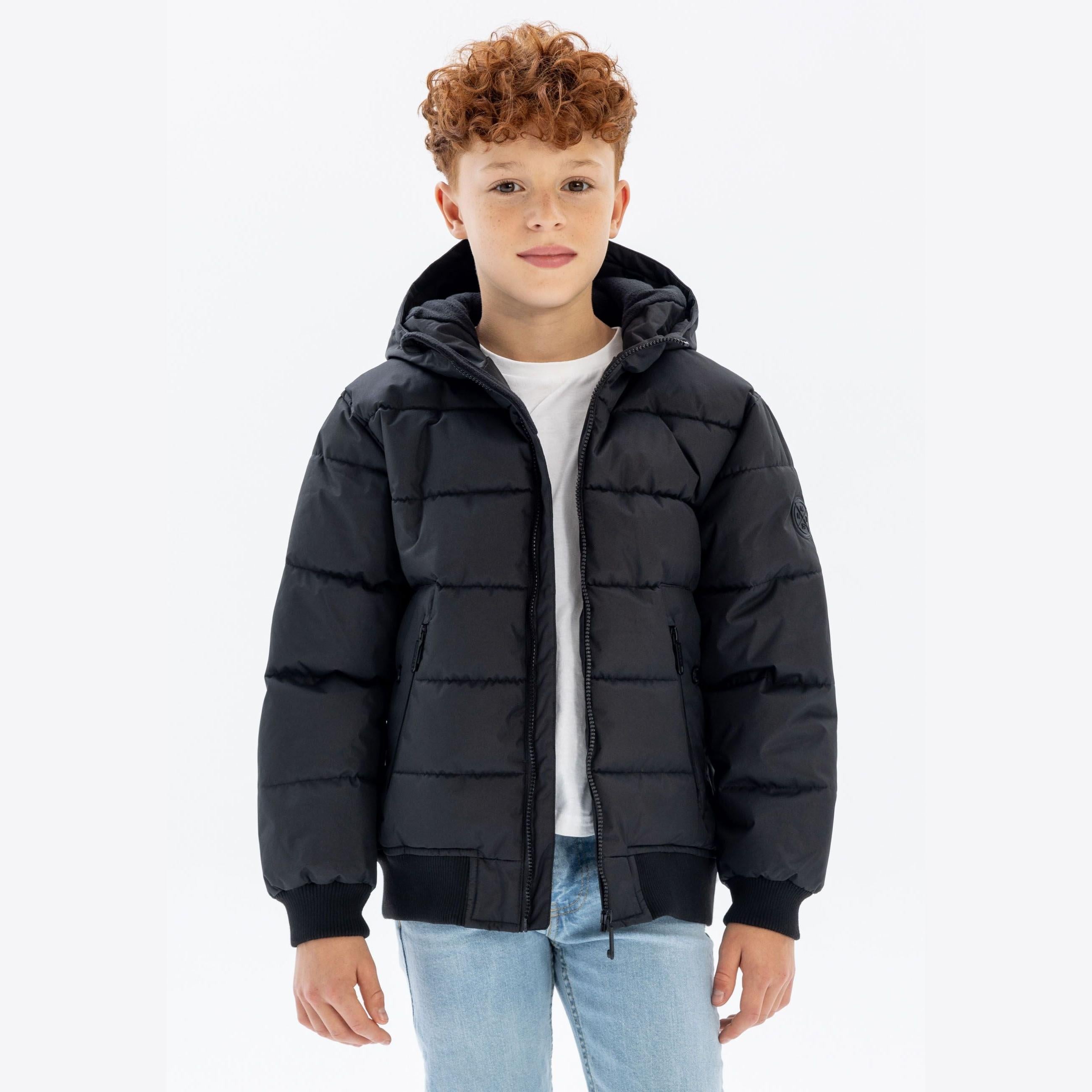 Same boy in black padded jacket showing front view of the quilted design and hood detail against white background