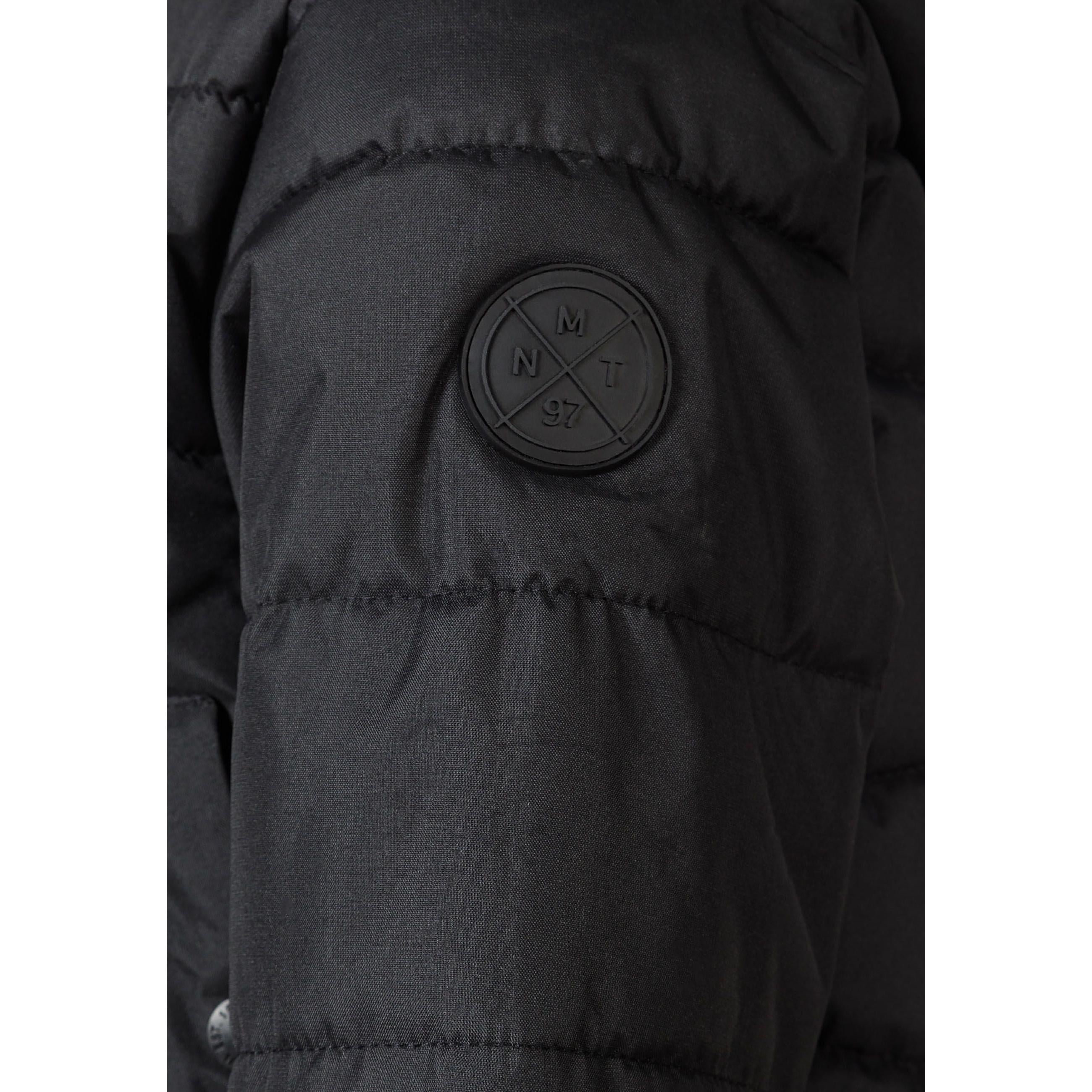 Close-up detail of black circular Minoti logo patch on the sleeve of the padded jacket showing MT 97 branding