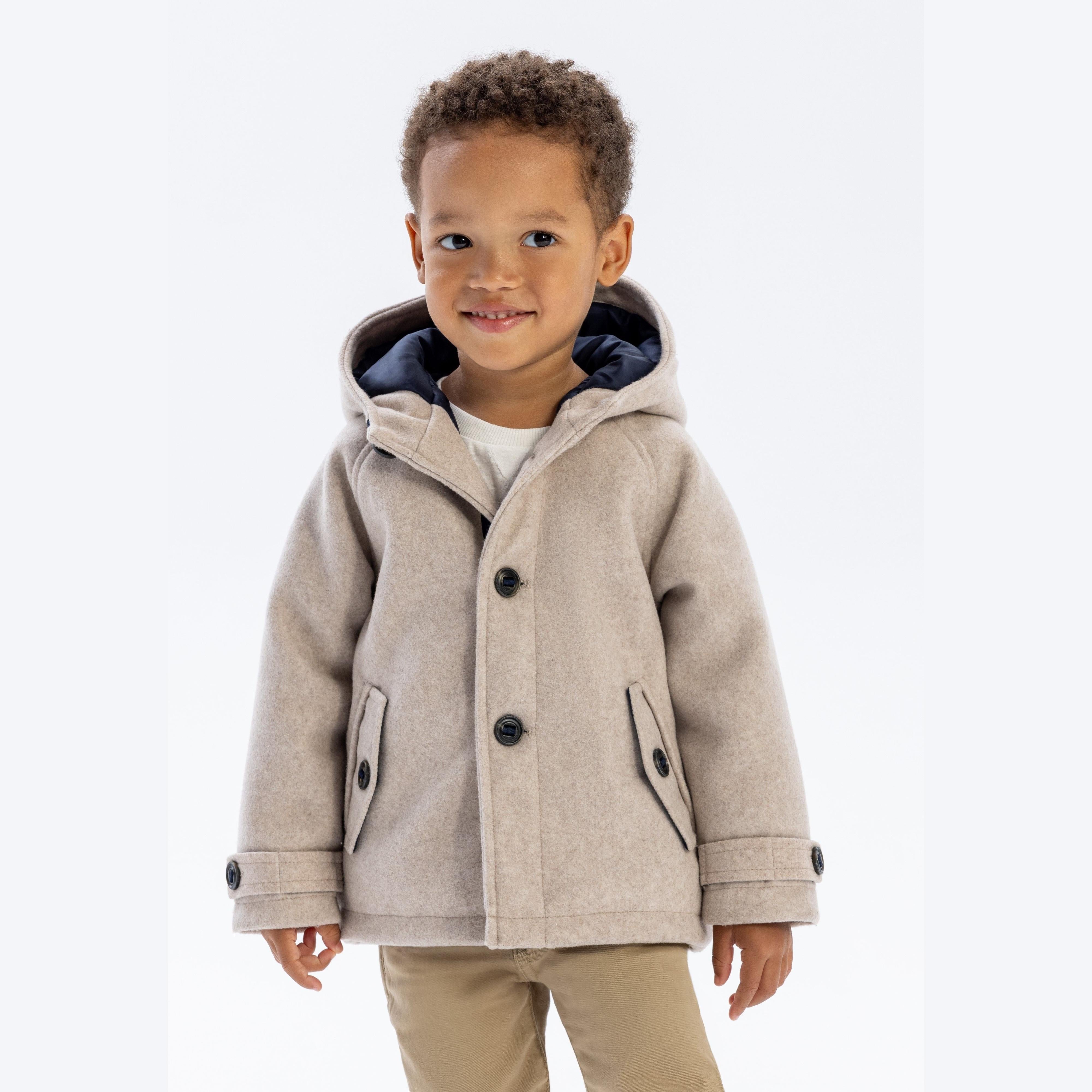 Young child wearing beige winter coat with hood up, showing front view with button fastening and structured collar against white background