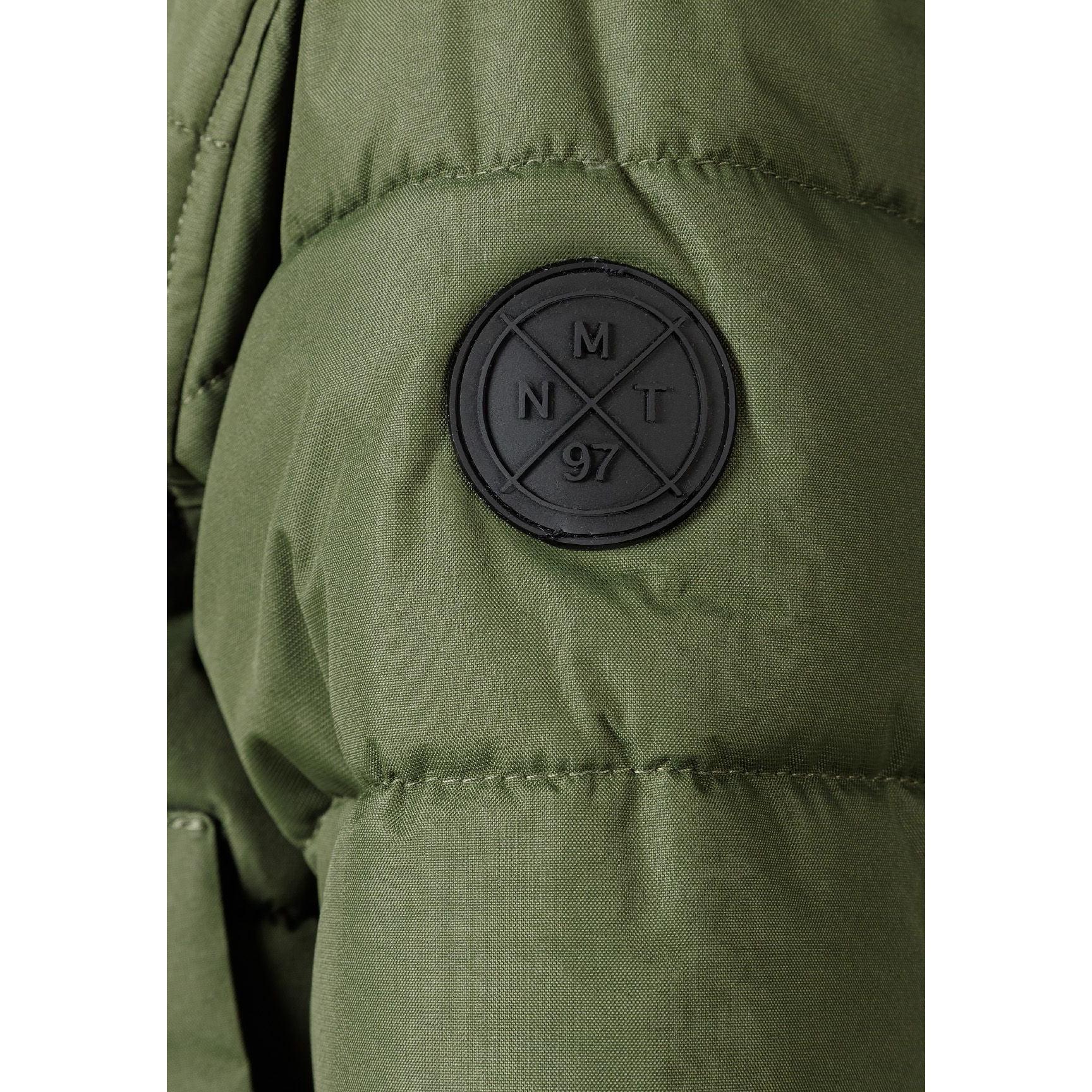 Close-up detail of khaki padded jacket showing circular black Minoti brand badge with crossed design and number 97
