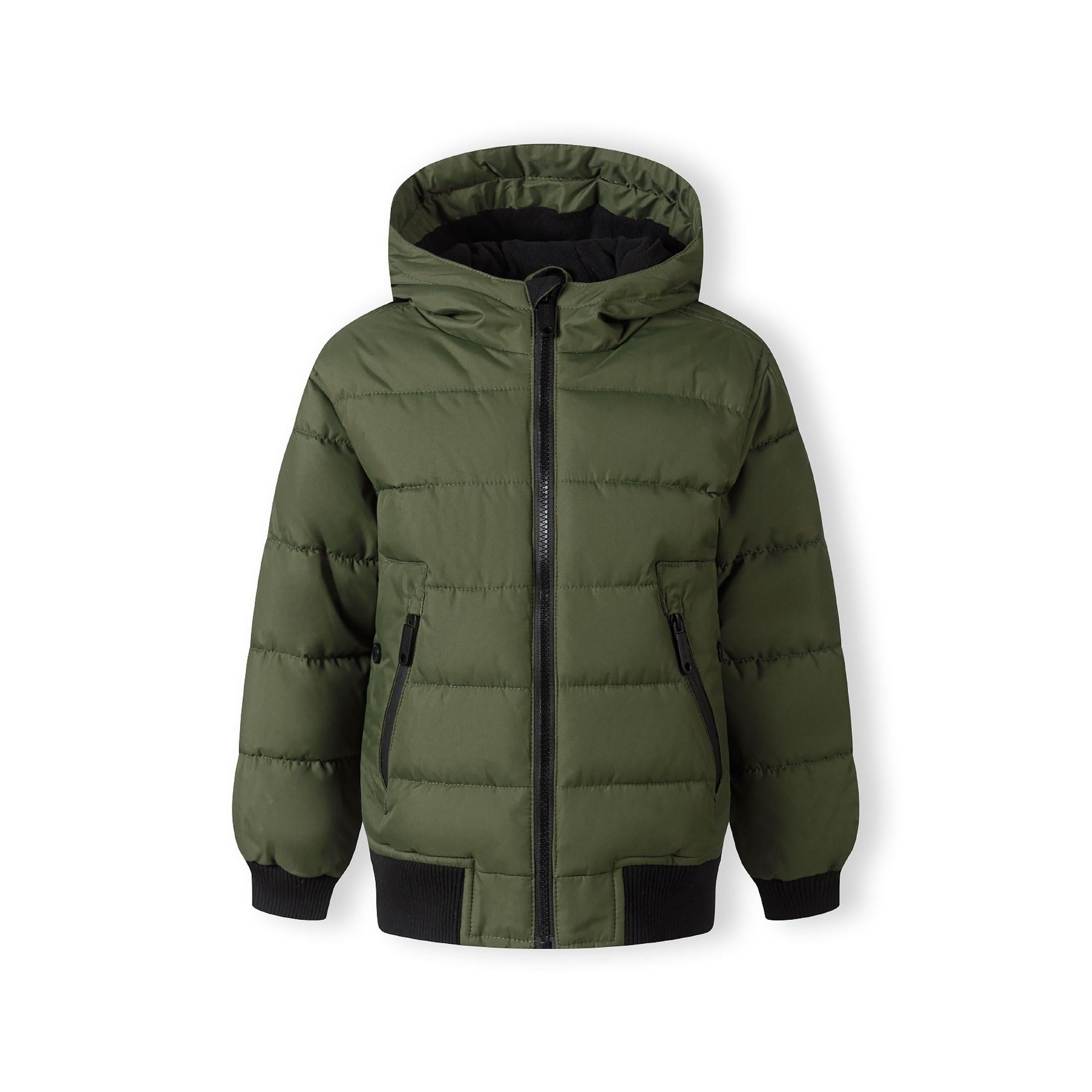 Close-up detail of khaki padded jacket showing circular black Minoti brand badge with crossed design and number 97