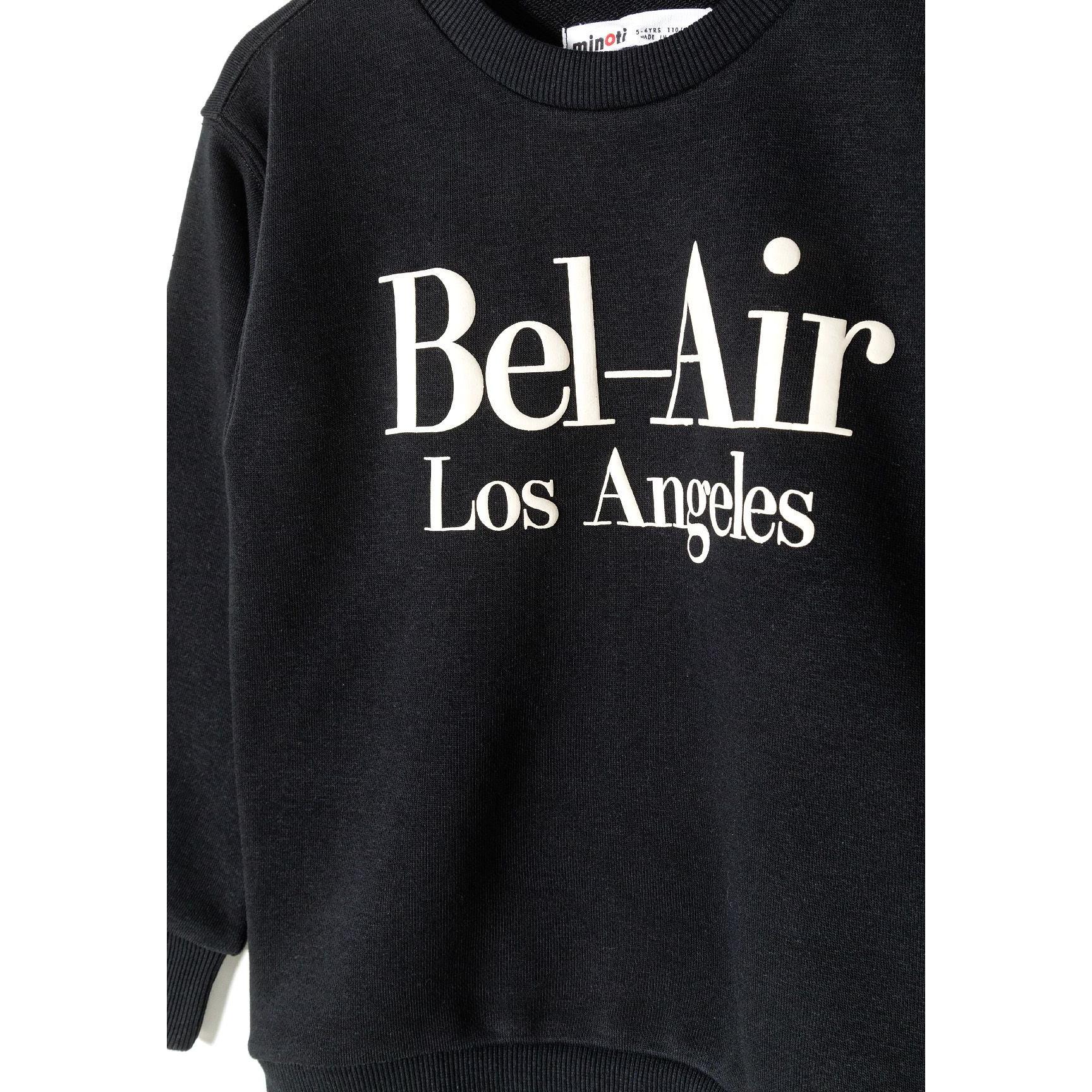 Close-up detail of black sweatshirt showing white Bel-Air Los Angeles text print on chest with Minoti label visible at neck