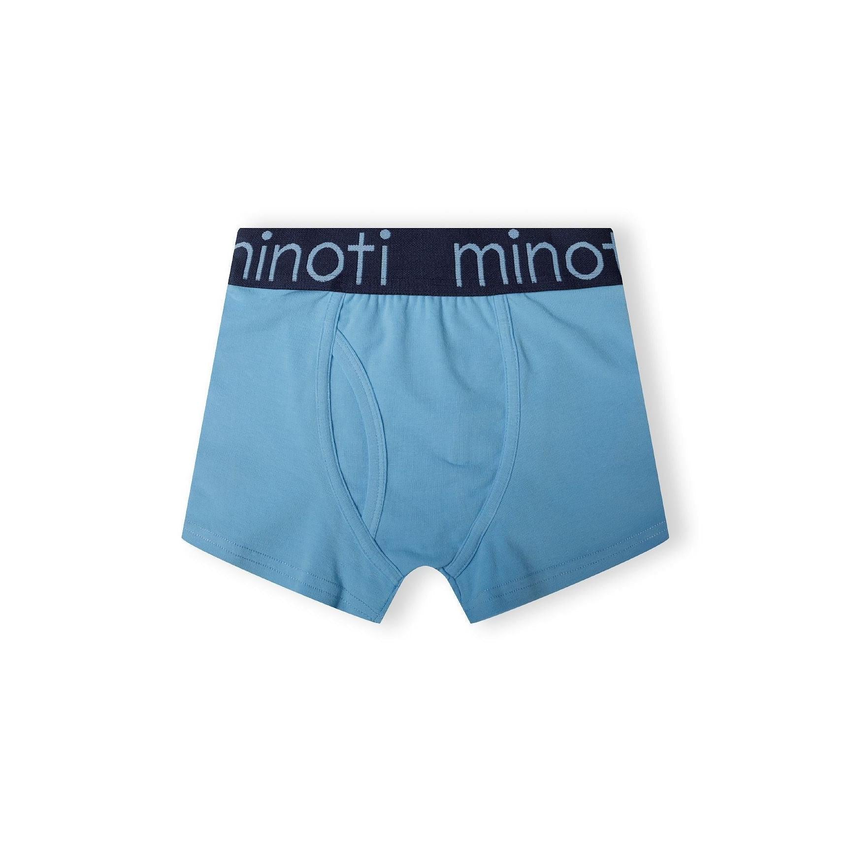 Single medium blue trunk with branded elastic waistband featuring Minoti logo, front view on white background showing classic fit