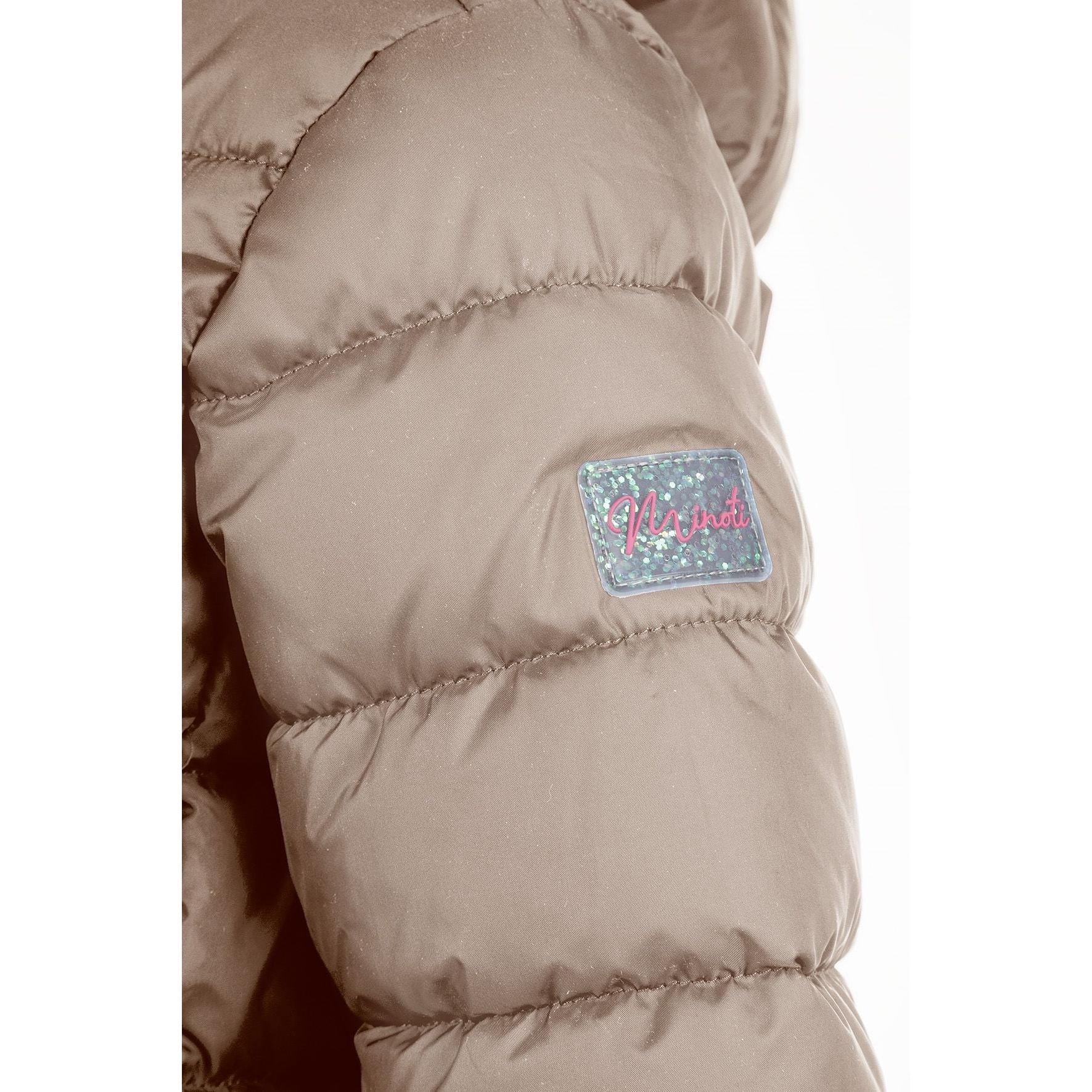 Detailed view of beige quilted jacket construction showing padded panels, zip mechanism and hood design elements, soft neutral lighting