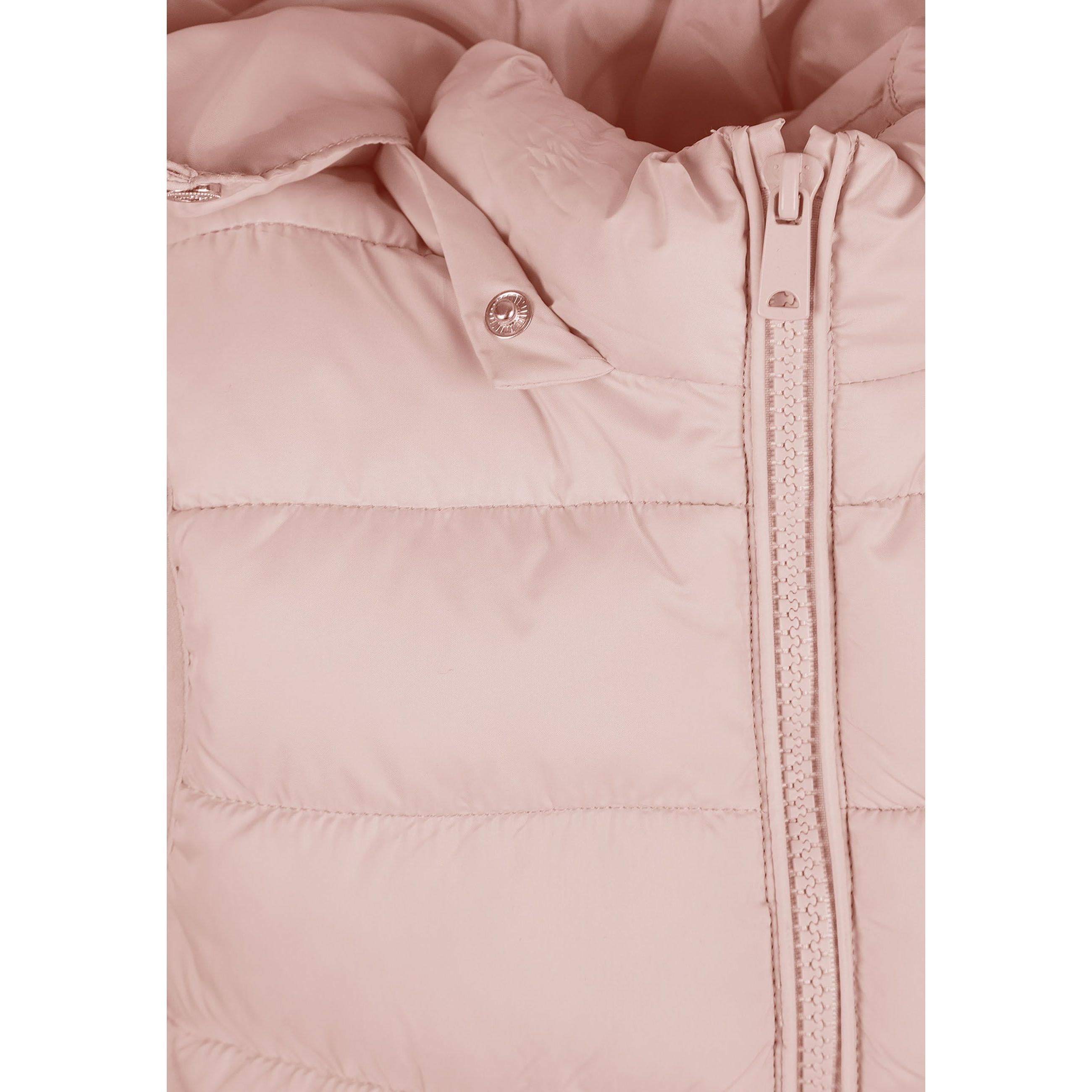 Close-up detail of pink quilted fabric showing stitched panels and clear branded patch with pink Minoti logo at bottom hem