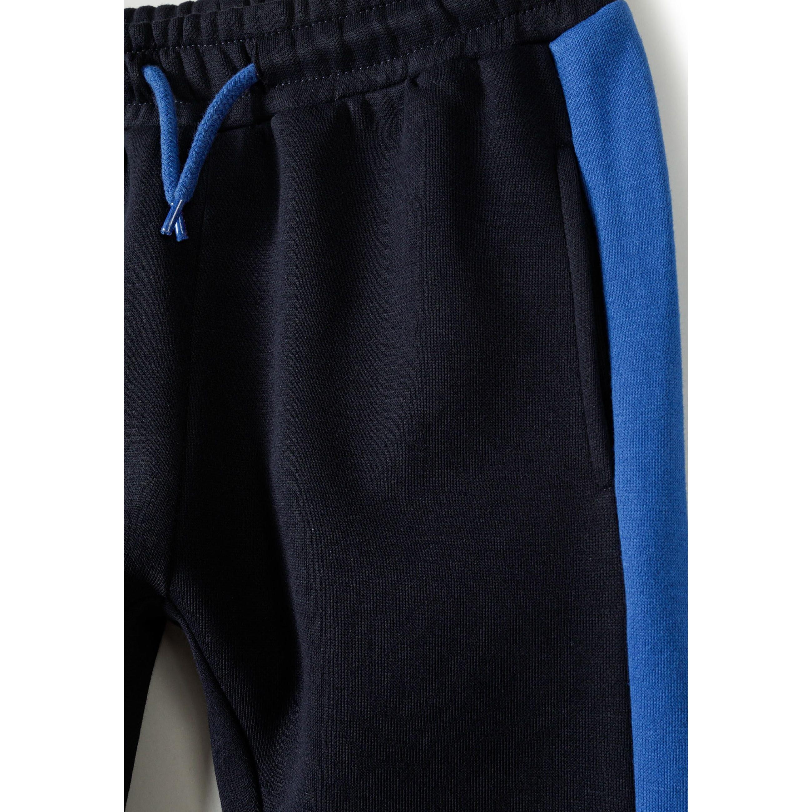 Close-up detail of navy jogger waistband with blue drawstring ties and side panel construction